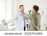 Portrait of aggressive male patient fighting and arguing with doctor standing in medical clinic. Angry man dissatisfied with treatment and and yelling at physician. Medicine concept.