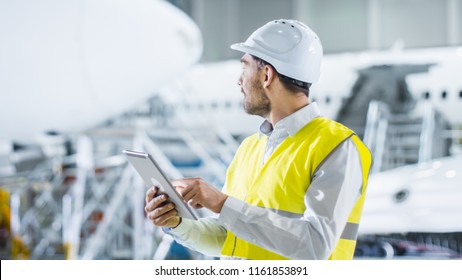 Portrait of Aircraft Maintenance Mechanic in Safety Vest using Tablet Computer