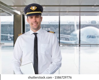 Portrait Of Airline Pilot Standing In Airport Lounge