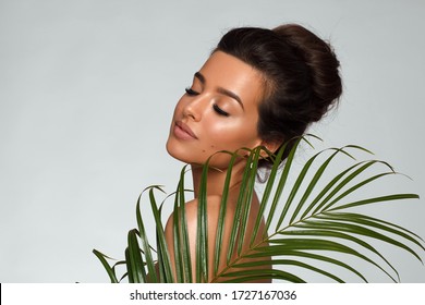 Portrait Of Amazing Beautiful Woman With Juicy Fresh Green Leaf Grass Near Her Face. Spa Concept For Face And Body Skin Care. Natural Beauty Girl Isolated On Grey Background. Youth Wrinkles