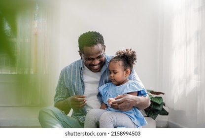 Portrait Of American African Black Father And Be Loved Daughter Hug Bonding In Living Room. Happy Daddy His Little Girl Spending Leisure Time At Home. Single Dad, Family Lifestyle Father's Day Concept