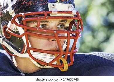 Portrait of a American Football Player with a heavily worn helmet