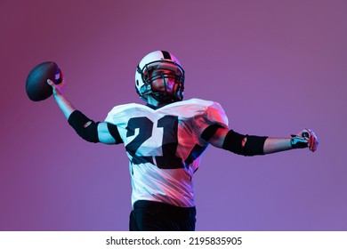 Portrait of american football player in motion, throwing ball in isolated over purple background in neon light. Active player. Concept of team game, energy, sport, competition. Copy space for ad - Powered by Shutterstock