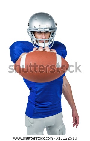 Portrait of American football player showing ball against white background