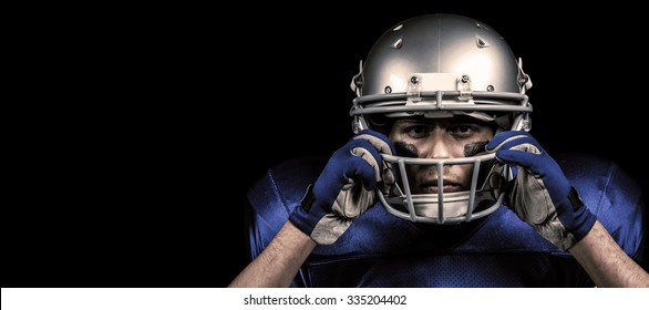 Portrait Of American Football Player Wearing Helmet Against Black