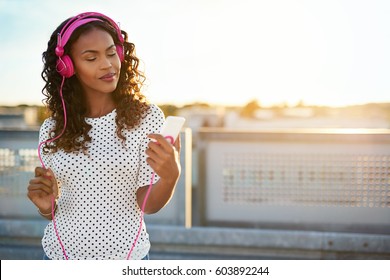 Portrait Of  African American Lady On A Blurry Background Enjoying Music