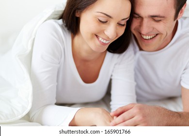 Portrait Of Amorous Young Couple Laughing In Bed