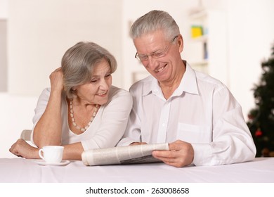 Portrait Of Amusing Old Couple Reading Newspaper