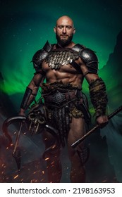 Portrait Of Ancient Nordic Warrior Dressed In Armor Holding Axe Against Northern Lights.