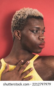 A Portrait Of An Androgynous Black Guy On A Red Background. LGBTI Concept