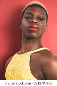 A Portrait Of An Androgynous Black Guy On A Red Background.