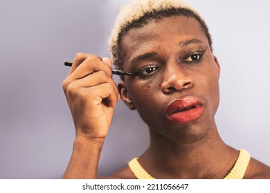 The Portrait Of An Androgynous Black Man Putting On Eye Makeup.