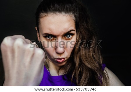 Portrait of an angry girl. Shows a fist