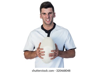 Portrait Of An Angry Rugby Player Holding Ball Over White Background