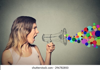 Portrait Angry Screaming Young Woman Holding Megaphone Isolated On Grey Wall Background. Negative Face Expression Emotion Feelings. Propaganda, Breaking News, Power, Social Media Communication Concept