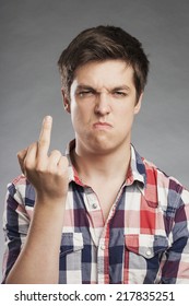 Portrait Of Angry Teenager Boy Holding Up Middle Finger