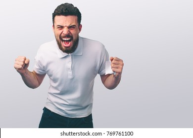 Portrait Of A Angry Young Man. He Is Clenches Fists And Shouts.. The Wicked Guy Beats .