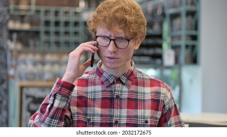 Portrait of Angry Young Redhead Young Man Talking on Phone
