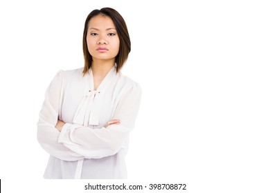 Portrait of angry young woman standing with arms crossed on white background
