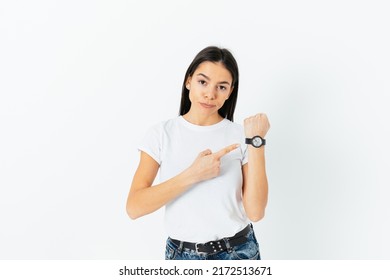 Portrait Of Annoyed Young Woman Points To The Clock, Says You Late Again, Bad Time Management