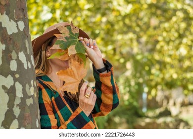 Portrait Of An Anonymous Young Woman Covering Her Face With Dried Leaves.