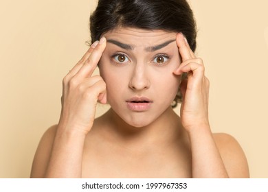 Portrait Of Anxious Young Indian Woman Touch Face Worry About Wrinkles Think Of Botox Treatment. Unhappy Mixed Race Female Frustrated With Skin, Need Anitiage Procedure. Skincare Concept.