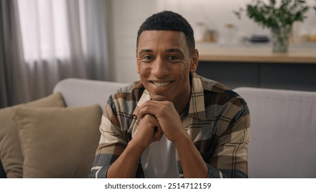 Portrait at apartment own real estate house at home couch sofa African American ethnic man smiling biracial male guy homeowner householder smile sitting indoors looking at camera happy renter joyful - Powered by Shutterstock