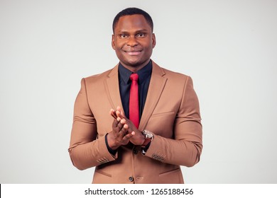 Portrait Of Applauding Handsome Afro-American Man ,businessman Clapping In A Stylish Dark Suit In The Studio On A White Background