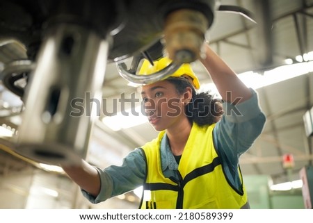 Portrait of apprentice female engineer working in workshop of heavy heavy industry factory. Business industry human resource. 