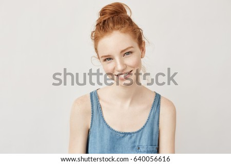 Portrait of appy beautiful redhead girl with freckles smiling sincerely looking at camera not afraid of uv and sunburns.