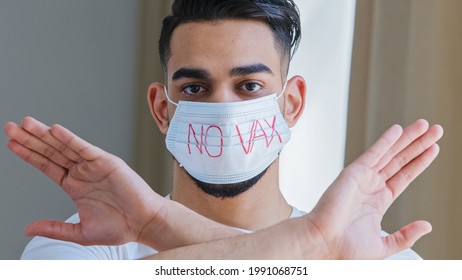 Portrait Of Arab Hispanic Man In Medical Protective Mask With Inscription No Vaccine Crosses Arms In Front Of Him Refusing Demonstrating Protest Refusal To Be Vaccinated Against Covid Coronavirus Flu