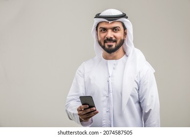 Portrait of arabic man with kandora in a studio - Handsome middle eastern adult male with traditional emirates dress