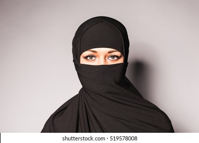 Portrait of an arabic young woman with her beautiful blue eyes in traditional islamic cloth niqab. - Shutterstock ID 519578008