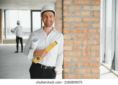 Portrait of an architect builder studying layout plan of the rooms, serious civil engineer working with documents on construction site, building and home renovation, professional foreman at work - Shutterstock ID 2185859075