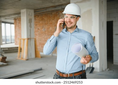 Portrait of an architect builder studying layout plan of the rooms, civil engineer working with documents on construction site, building and home renovation, professional foreman at work