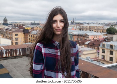portrait of an Armenian girl with fluttering long dark hair  on a rooftop in  St. Petersburg