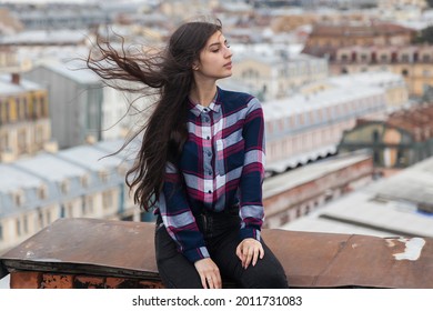 portrait of an Armenian girl with fluttering long black hair on rooftop