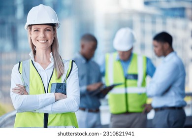 Portrait, arms crossed and a woman construction worker outdoor on a building site with her team in the background. Management, leadership and confidence with a female architect standing outside - Powered by Shutterstock