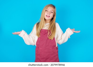 So what? Portrait of arrogant caucasian little kid girl wearing jumpsuit over blue background shrugging hands sideways smiling gasping indifferent, telling something obvious. - Shutterstock ID 2079978946