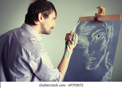 Portrait of an artist painting on easel. Shot in a studio. - Powered by Shutterstock