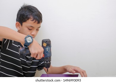 Portrait of an Asean young boy  assembling new furniture at home. DIY Concept