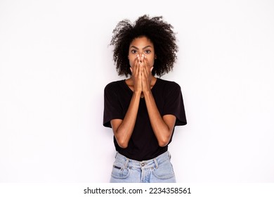 Portrait of ashamed young woman covering mouth with hands over white background. African American lady wearing black T-shirt and jeans standing worried over failure. Stress and mistake concept - Powered by Shutterstock