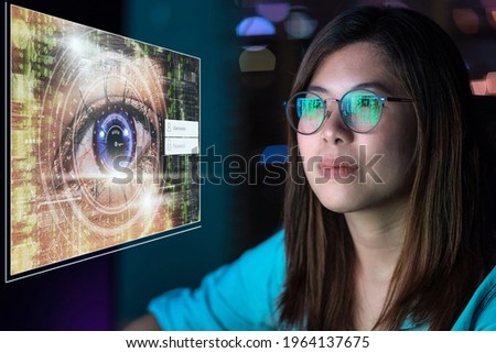 Portrait of Asia Businesswoman sitting and working hard via eye authentication with username and password over Closeup women eye with futuristic digital technology in work place, work late aconcept