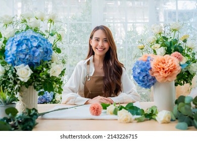 portrait Asia Female florist smile arranging flowers in floral shop. Flower design store. happiness smiling young lady making flower vase for customers, preparing flower work from home business - Powered by Shutterstock