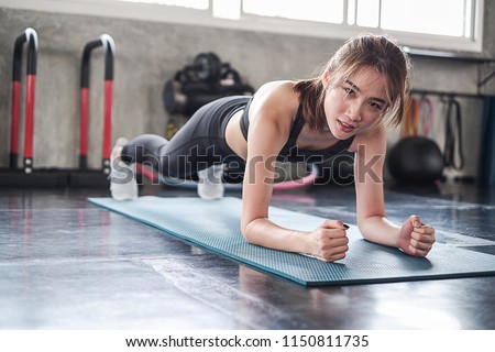 Portrait asia woman doing plank on mat working out or exercise and wearing sportswear in fitness or gym center, Strength sporty female and weight loss concept