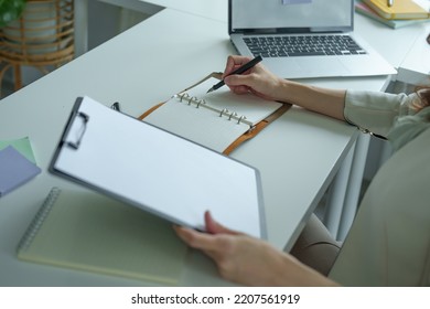 Portrait Of An Asian Bank Employee Using Notebooks To Take Notes, Budget Documents And Computers To Close Financial Statements.