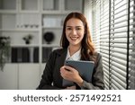 Portrait of Asian beautiful businesswoman smiling while work in office. Attractive professional female employee worker in formal wear standing with confidence at workplace and looking at camera.