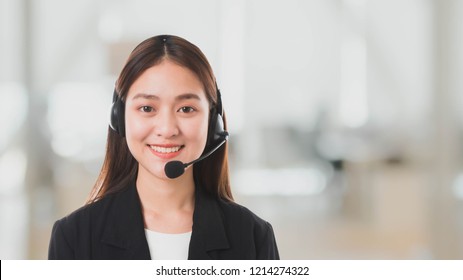 Portrait Of Asian Beautiful Smiling Woman Customer Support Phone Operator In Office Space Banner Background And Copy Space.Concept Call Center Job Service.