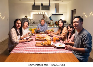 Portrait Of Asian Big Happy Family Having Dinner Together In House. Senior Elder Grandparent Spend Time With Young Relative Visitor Eat Food On Dinner Table And Enjoy Party Then Look At Camera At Home