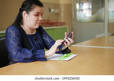 Portrait Of Asian Blind Person Woman In Wireless Earphones Using Smart Phone With Voice Accessibility Technology For Persons With Disabilities In Office Workplace.